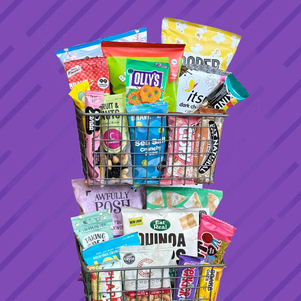 Basket filled with various snack packets on a purple background